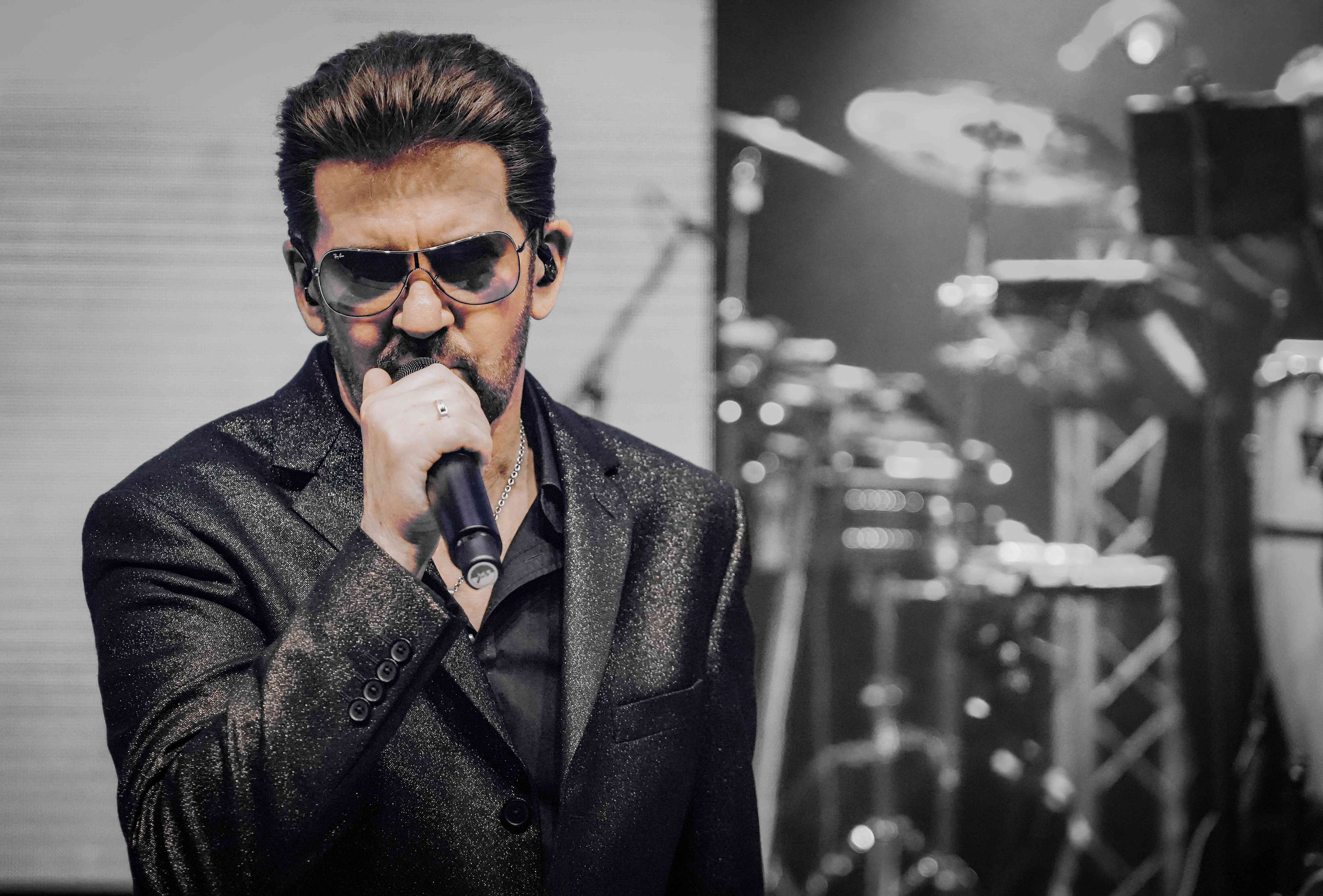 Artistic black and white shot of Steve Mitchell with drums in background