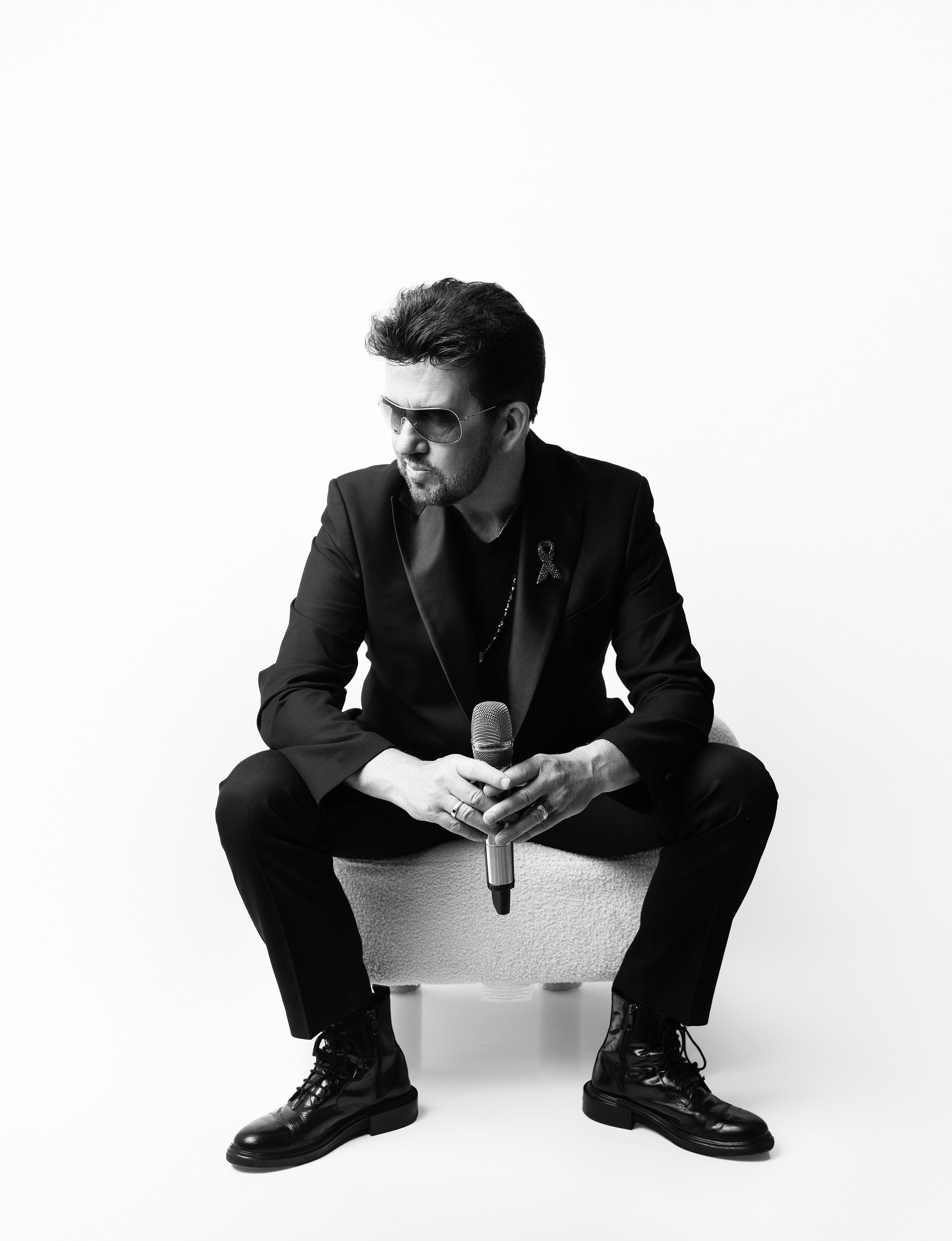 Black and white portrait of Steve Mitchell sitting with microphone