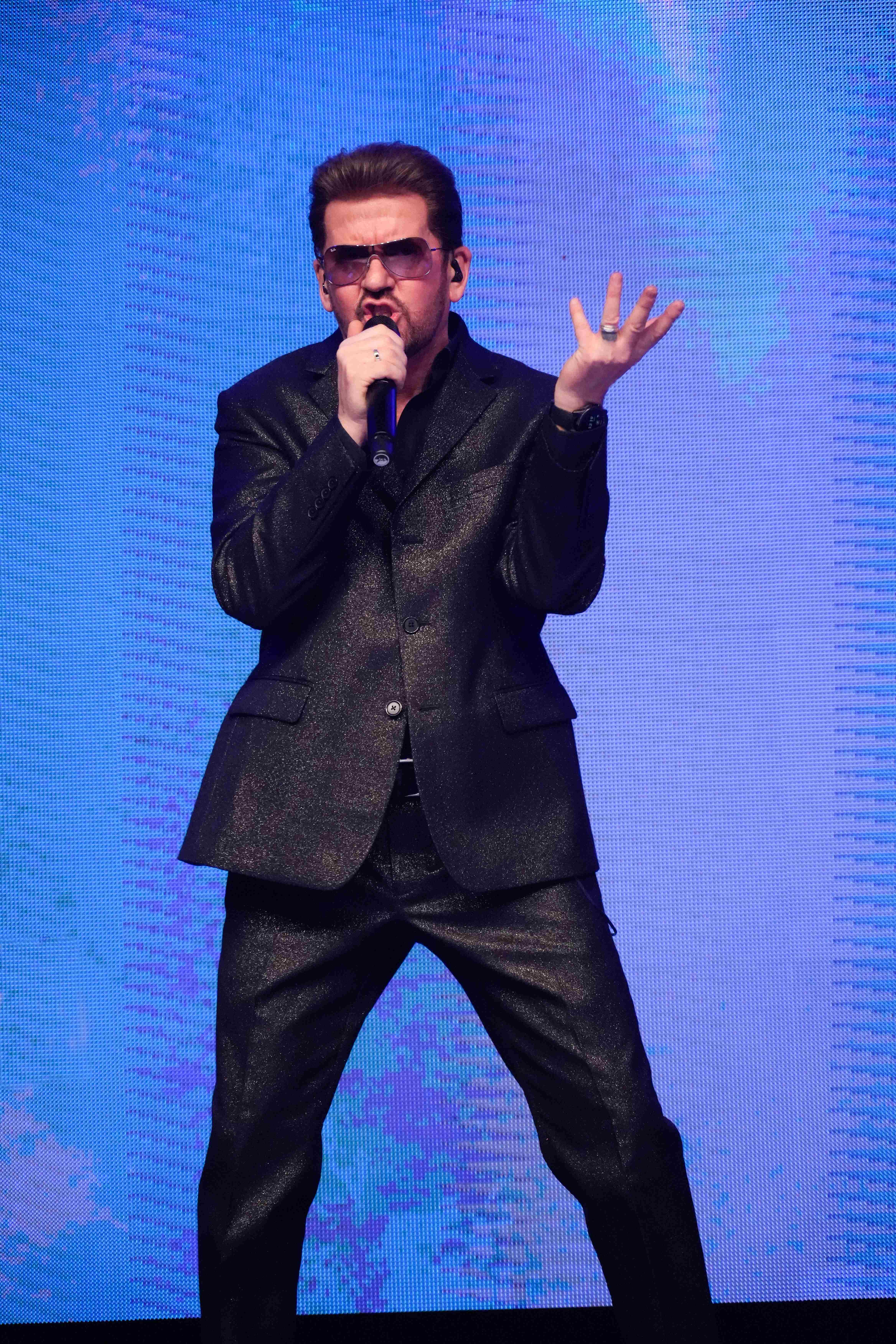 Steve Mitchell in full performance mode against bright blue LED backdrop