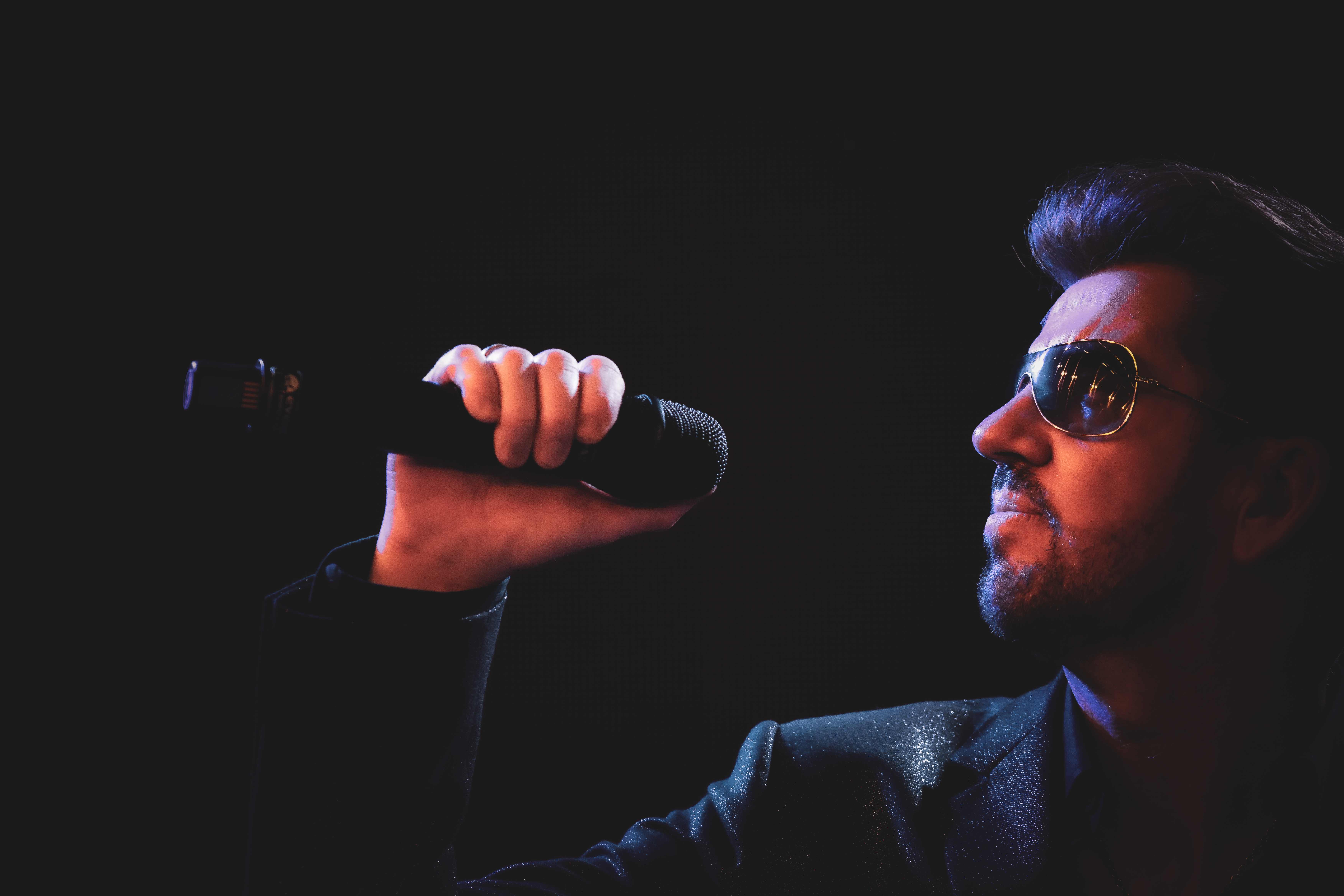 Dramatic close-up of Steve Mitchell singing with moody stage lighting