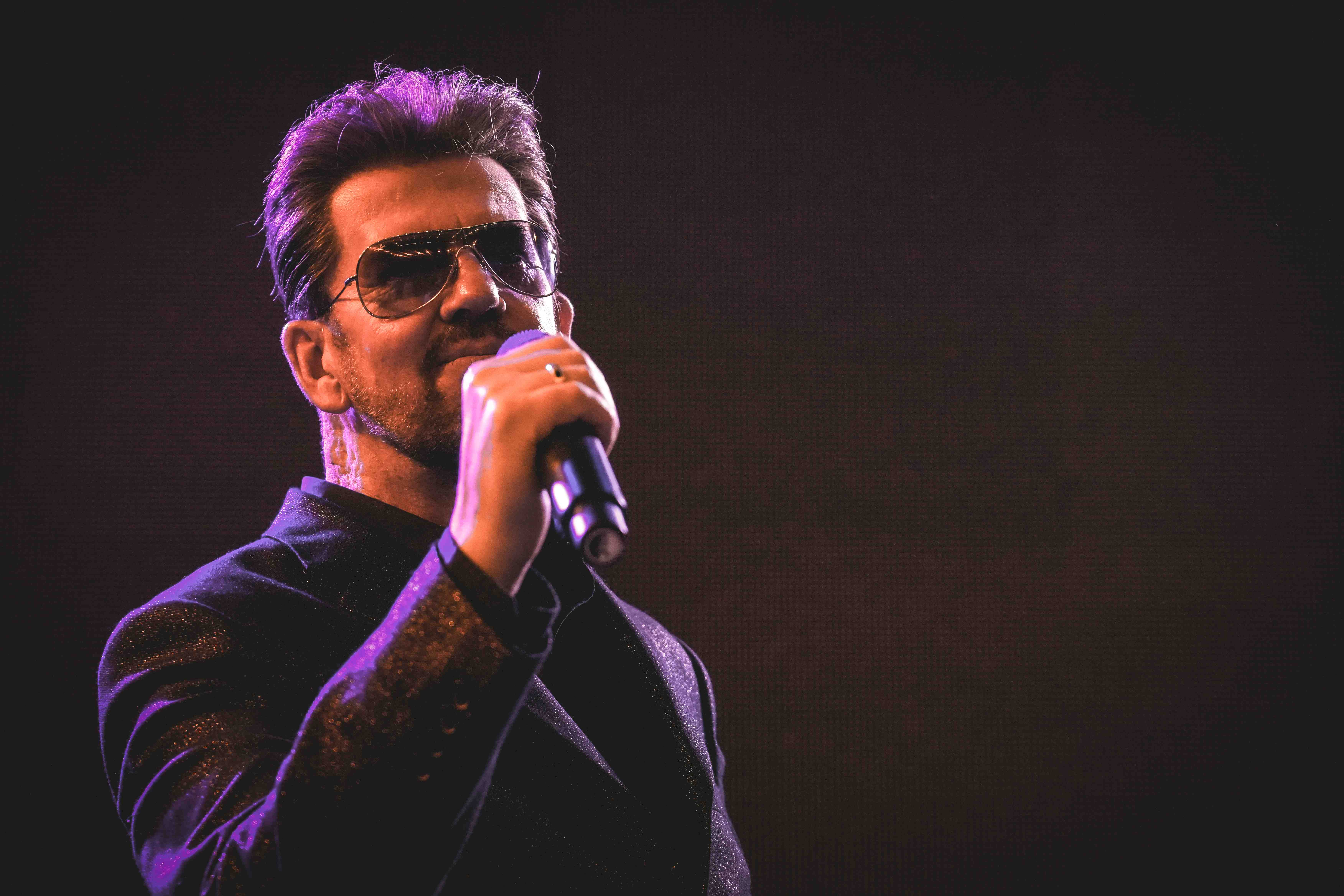 Steve Mitchell in sparkly suit with purple/pink stage lighting